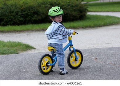 2 Years Old Child Learning To Ride On His First Bike