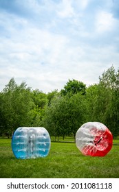 2 Zorbing Balloon on the summer lawn. inflatable zorb ball outdoor. Leisure activity concept with vertical copy space.