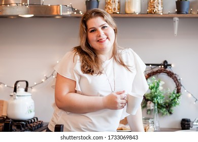20 APRIL 2020: RUSSIA, STAVROPOL.overweight girl drinks coffee in a white kitchen - Shutterstock ID 1733069843