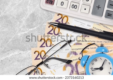 20 Belorussian rubles bills and calculator with glasses and pen. Business loan or tax payment season concept. Financial planning and time to pay taxes