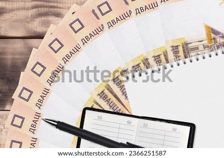 20 Belorussian rubles bills fan and notepad with contact book and black pen. Concept of financial planning and business strategy. Accounting and investment
