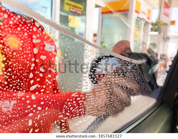 20 Nov 2020 Shell gas
station employees are wiping car windows that have been blurred
with laminated film due to taking pictures through a windshield
cleaner