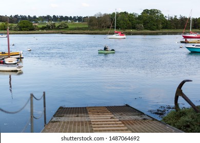 A 20 Something Male In A Row Boat With His Dog Sitting On His Lap While They Row Down The River Deben, Suffolk