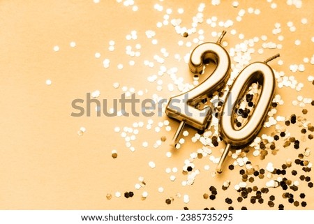 20 years celebration festive background made with golden candles in the form of number Twenty lying on sparkles. Universal holiday banner with copy space.