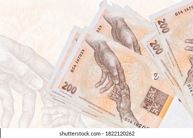 200 Czech korun bills lies in stack on background of big semi-transparent banknote. Abstract presentation of national currency