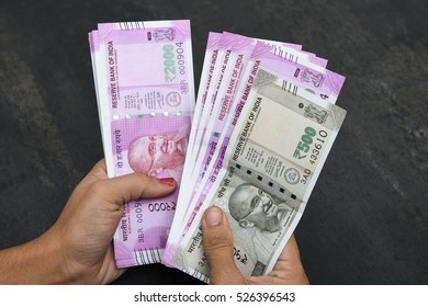 2000 And 500 Rupee India,The Brand New Indian Currency Notes Of 2000 Rupees Isolated On Black. These Have Been Introduced To Curb Black Money. Business Women Holding Counting Newly Launched Rs 