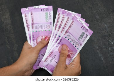 2000 Rupee India,The Brand New Indian Currency Notes Of 2000 Rupees Isolated On Black. These Have Been Introduced To Curb Black Money. Business Women Holding Counting Newly Launched Rs 