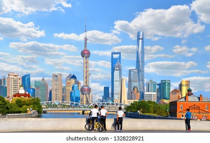 20.05.2017. Local People With Bicycles Observe Historical Waibaidu Bridge In Front Of The Futuristic Modern Skyline Of Pudong Shanghai, China