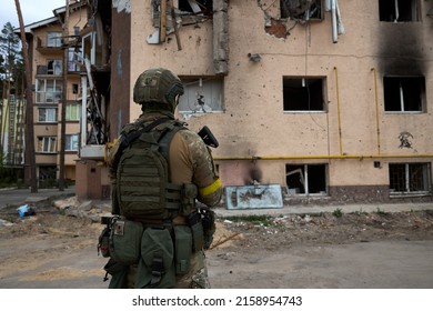 20.05.2022 Ukraine. Irpin. A Ukrainian Soldier Stands And Looks At The Bombed Houses By The Russian Army In Irpin. High Quality Photo