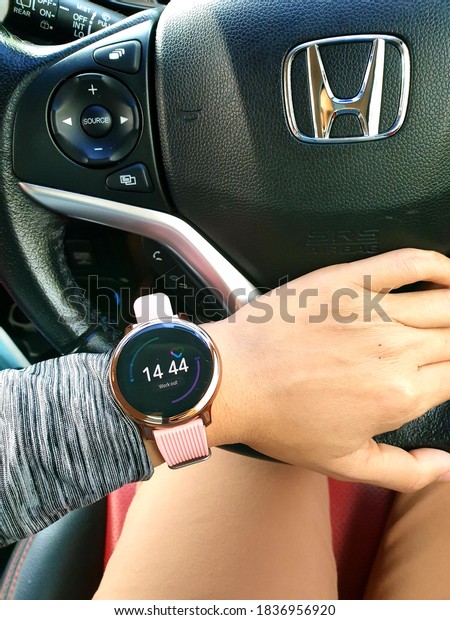 20.10.2020, Kuala\
Lumpur, Malaysia: The left hand wearing a smart watch shows useful\
info to the user while holding the steering wheel of the car.\
Lifestyle and technology\
concept.