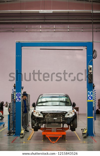 2012, Vladivostok - Automotive Plant.\
Disassembled cars are in a large bright\
workshop.