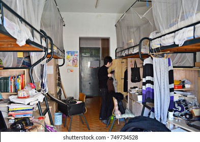 2012.3.25, A Male Student Standing In A Typical On-campus Dormitory Room With Bunk Beds And Desks For University Students, Zhejiang University City College, Hangzhou, China.