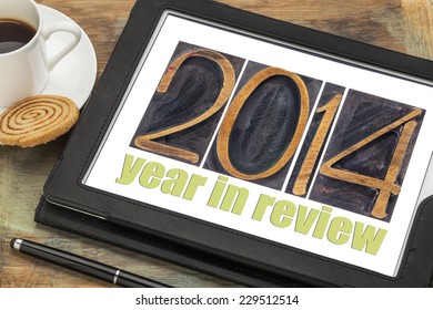 2014 year in review - text in letterpress wood type on a digital tablet with cup of coffee