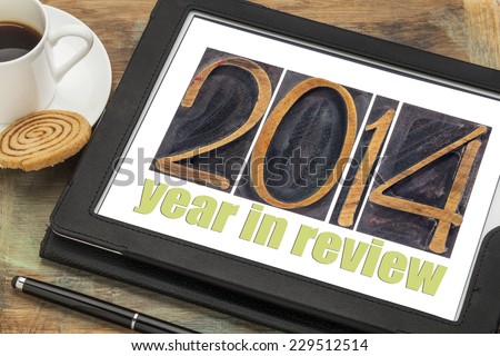 2014 year in review - text in letterpress wood type on a digital tablet with cup of coffee