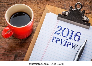 2016 review on clipboard with coffee against grunge wood desk
