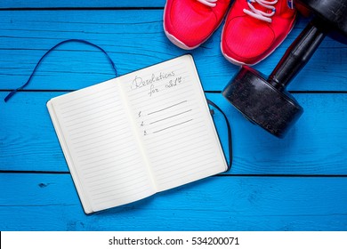 2017 Goals And Resolutions On Blank Notebook Paper, Dumbbell And Sneakers On Blue Wood Background, Fitness, Sport And Health Concept, Top View