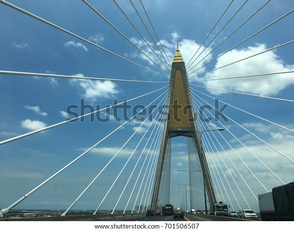2017, Kanchanaphisek Bridge, Bangkok, Thailand,
Image of cables suspended hang the deck of suspension bridge,
bright sky is backdrop.