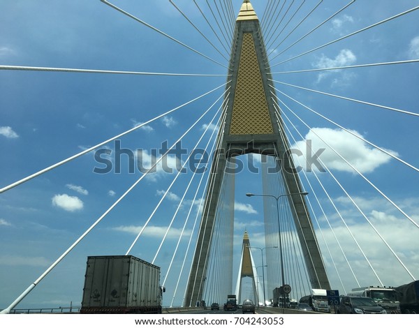 2017, Kanchanaphisek
Bridge, Bangkok, Thailand, Image of cables suspended hang the deck
of suspension bridge, bridge across the river, across town, bright
sky is backdrop.