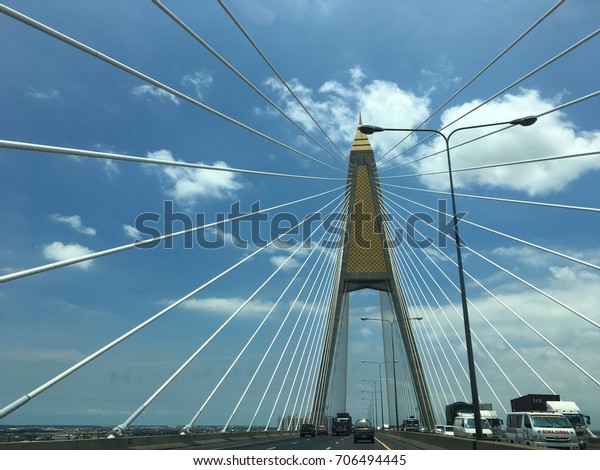 2017, Kanchanaphisek Bridge, Bangkok, Thailand,
Image of cables suspended hang the deck of suspension bridge,
bright sky is backdrop.
