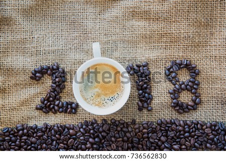 2018 coffee beans and white cup of coffee on sack texture background, New Year concept