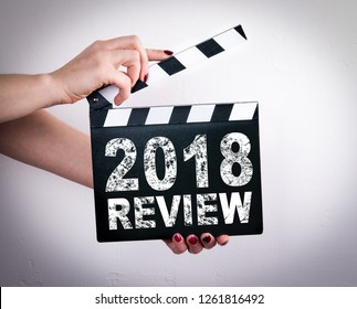 2018 Review Concept. Female Hands Holding Movie Clapper 