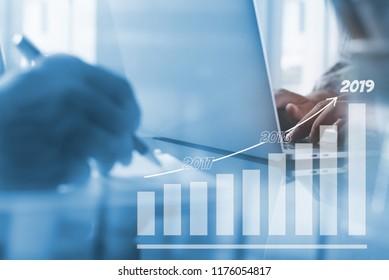 2019 Business Goals Setting On Improvement, Business Finance And Investment Concept. Businessman Working On Laptop Computer At Modern Office With Candlestick Financial Graph Interface