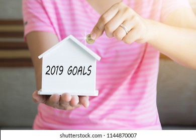 2019 Goals With Women Hand Putting Money Coin In Piggy Bank, Saving Money Concept, Concept Of Financial Savings To Buy A House, Growth, Business, Money.