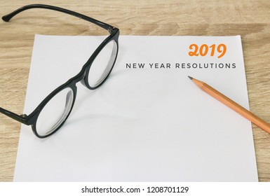 2019 New Year Resolution Note With Glasses And Pencil On Paper And Wood Table