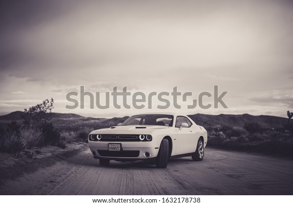 2019 White Dodge Challenger on\
desert road in southern California in black and white\
background