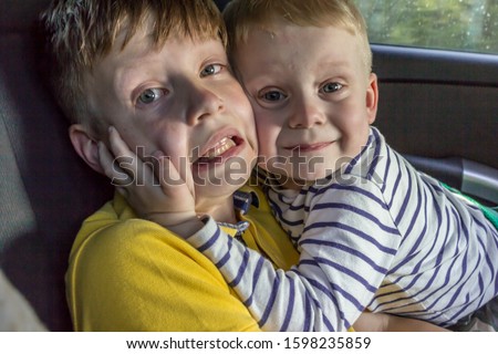2019.05.10, Tula, Russia. Two brothers having fun in a car. Two blonde boys hugging and laughing.