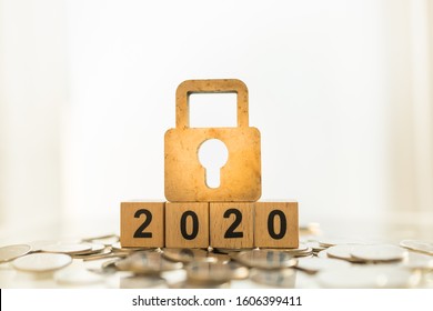 2020 Business, Planning, Finance And Money Security Concept. Close Up Of Wooden Master Key Lock Icon On Wood Number Block On Pile Of Coins With Copy Space.