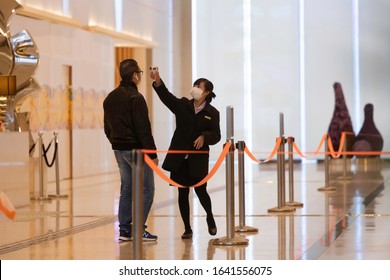 2020 Feb 10,Hong Kong.In The Lobby Of The Office, The Service Staff Detects The Temperature Of People Entering The Building To Prevent Pneumonia Infection.