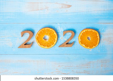 2020 Happy New Year And New You With Orange Fruit On Blue Wood Background. Goals, Healthy, Healthcare, Resolution, Time To New Start, Sport, Fitness And Dieting Concept.