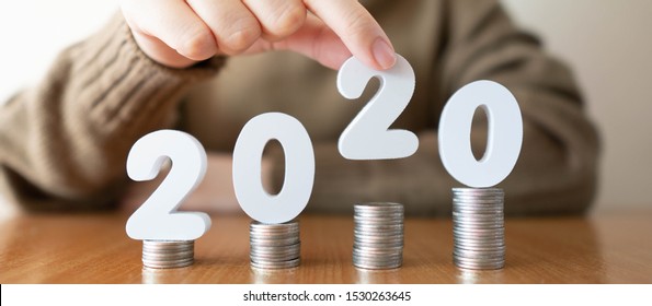 2020 New Year Saving Money And Financial Planning Concept. Female Hands Putting White Number 2020 On Stack Of Coins. Creative Idea For Business Growth, Tax Payment, Investment And Banking.