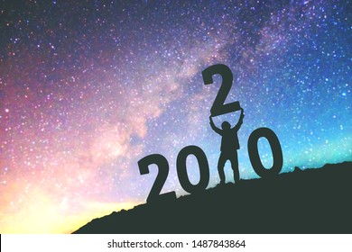 2020 Newyear Man Tries To Lift Up Number Of 2020 Happy New Year Background On  The Milky Way Galaxy 