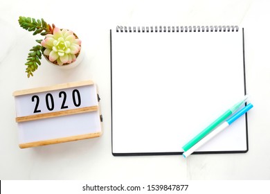 2020 On Wood Box, Blank Notebook Paper On White Marble Table Background, 2020 New Year Mock Up, Template With Copy Space For Text, Top View