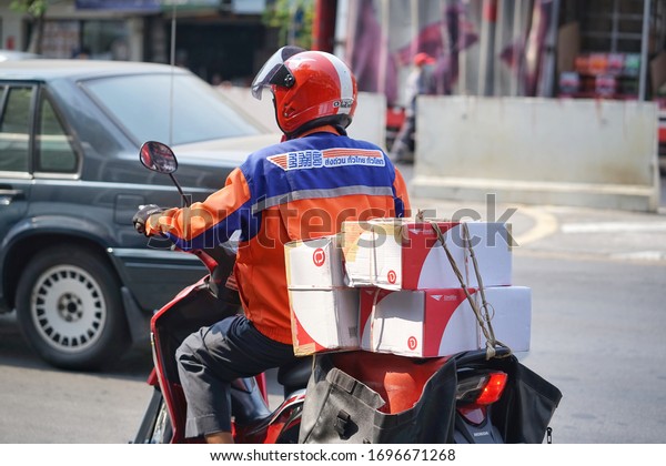 March​, 2020 :Unidentified​\
post man riding motorcycle to send parcel by motorcle at bangkok\
thailand