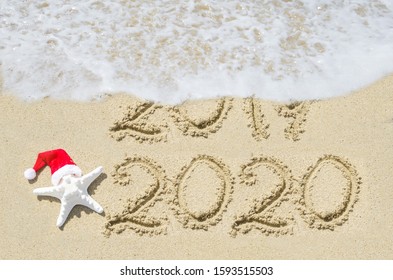 2020 year is coming concept, beach background near ocean with starfish in Santa Hat  - Powered by Shutterstock