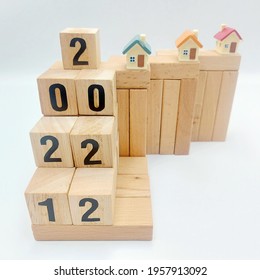 2021 And 2022 Housing Market Represented By Wooden Blocks And Miniature Houses