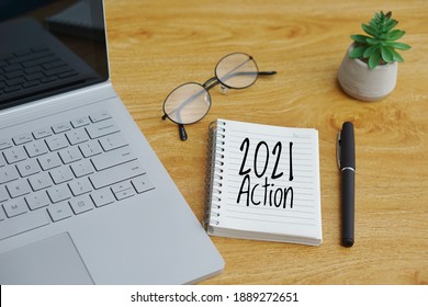 2021 Aktion geschrieben auf Notebook, Laptop, Brille und Stift auf Holzhintergrund. Ziel, Plan, Strategie, Aktion, Ideenkonzept. Leerzeichen kopieren

