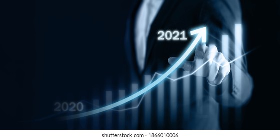 2021 business concept, business man try to predict economic by point and dragging the growth graph in year 2021 to make a benefit, profit, trend, market, success, grow up, turnover, financial,moeny - Shutterstock ID 1866010006