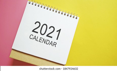 2021 Calendar Flat Lay On Pink And Yellow Background. Hello 2021, New Year New You, Goal Setting, Start Making Resolutions Theme. (top View, Close Up, Selective Focus, Space For Text)