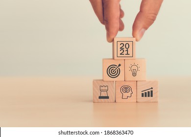 2021 concept business man hand arranging wood block . icon of business strategy including element with goal, idea, leadership, management of time, Knowledge, Initiative, Human relations in 2021 year - Shutterstock ID 1868363470