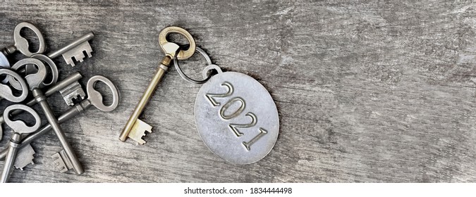 2021 engraved on a ring of an old key on wooden background 