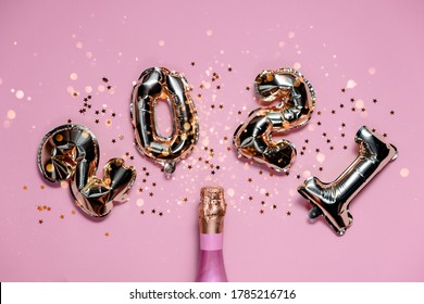 2021 golden foil balloons numbers with pink champagne and bokeh. Top horizontal view copy space new year and holiday concept
