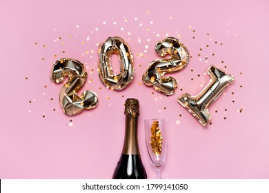 2021 golden foil balloons numbers, champagne, stars confetti, ribbons  and bokeh. Top horizontal view copy space new year and holiday concept.