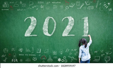 2021 Happy new year school class academic calendar with student kid's hand drawing greeting on teacher's green chalkboard for educational celebration, back to school, STEM education classroom schedule