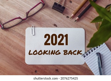 2021 looking back text on white card on office desk. Year highlights concept. Top view.  - Shutterstock ID 2076275425