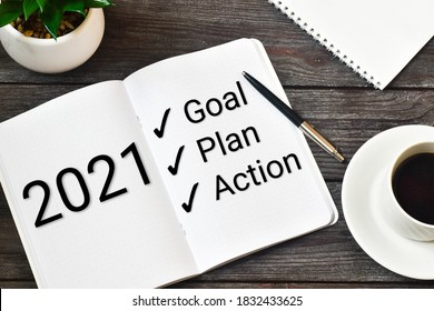 2021 New Year. Goal,plan, Action Text On Notepad With Office Accessories On A Wooden Background. Business Motivation, Inspection Concepts Ideas.