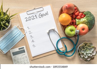 2021 New Year Goals In New Normal Lifestyle, Work-life Balance With Face Mask Safety Awareness From Covid-19, Healthy Food, Good Heart Health, Blank Resolution List On White Paper Medical Clipboard